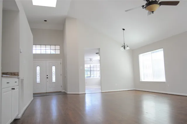 an empty room with wooden floor and windows