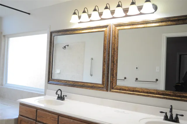 a bathroom with a sink a mirror and a vanity