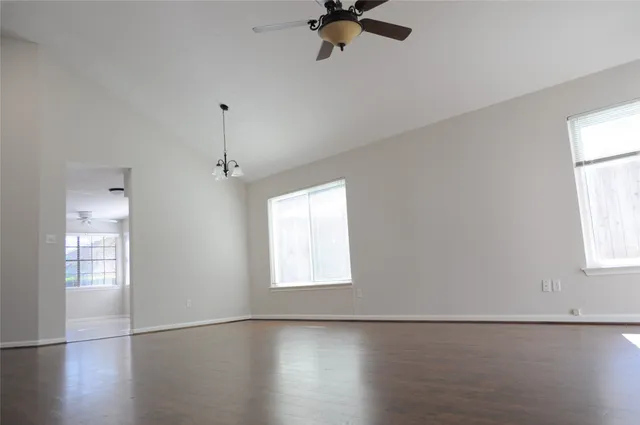 a view of a livingroom with wooden floor and a ceiling fan