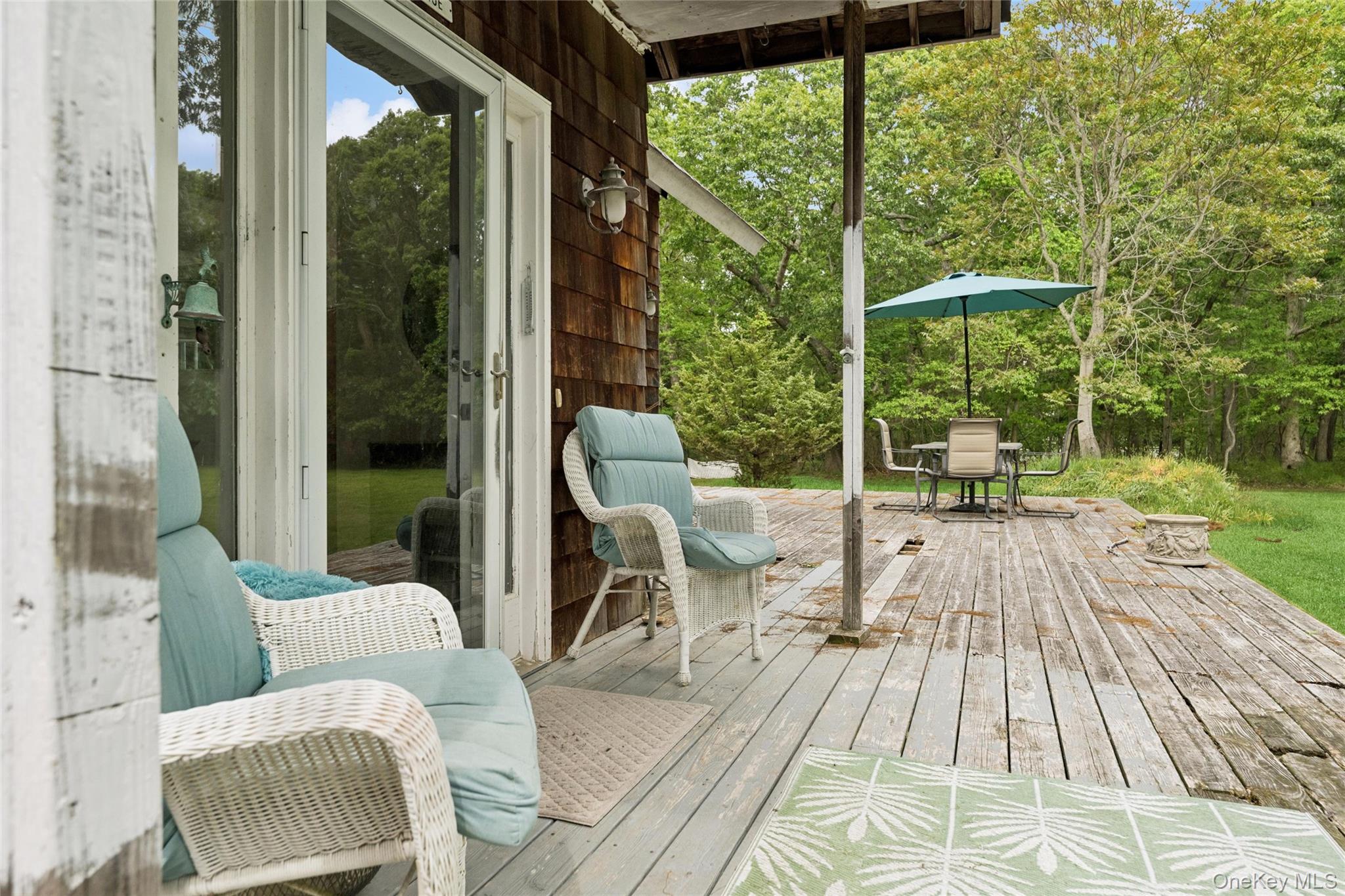 131 Red Creek Road Hampton Bays, NY 11946 - Photo 5 of 35 a view of balcony with couch and chairs