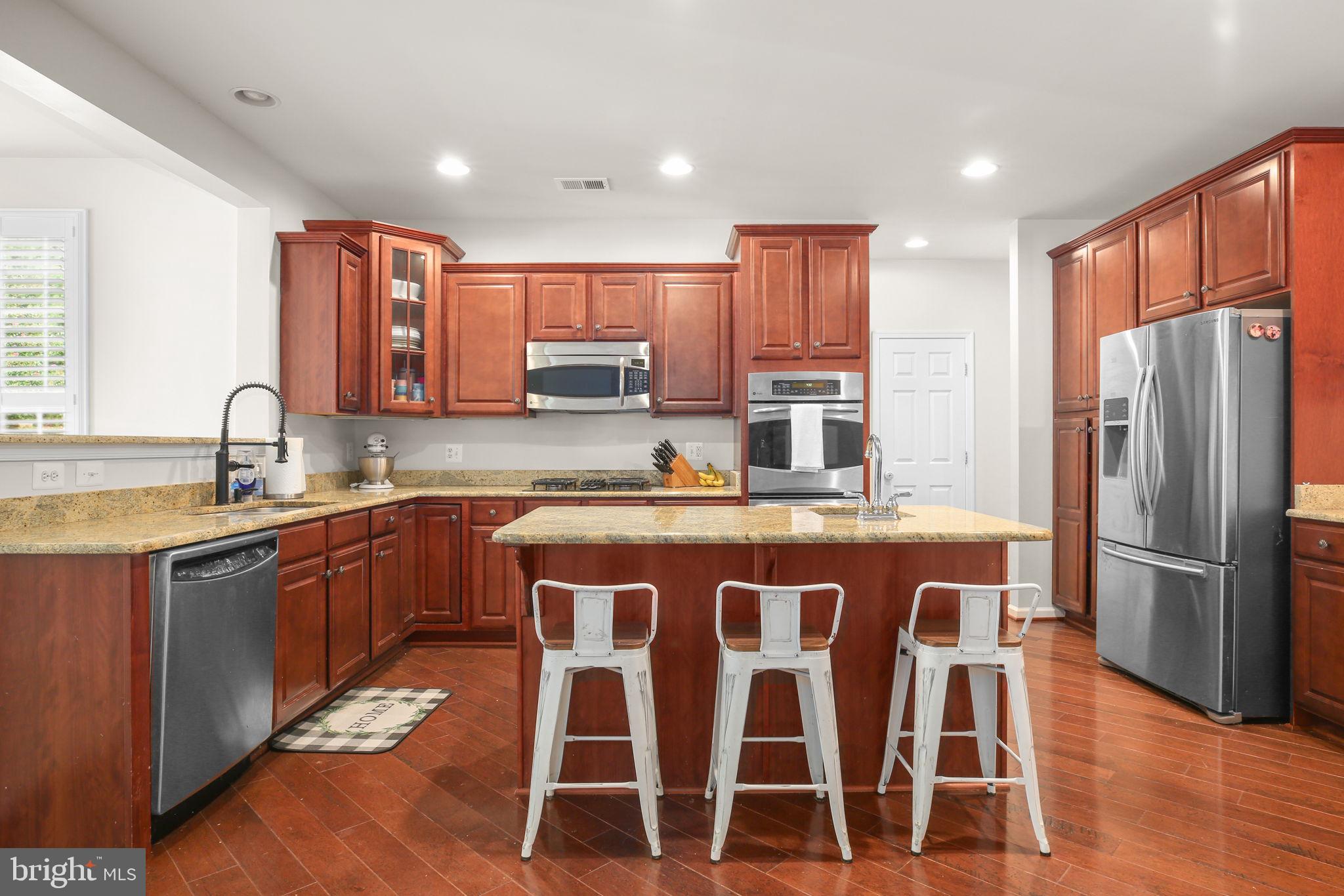 10108 Willow Ridge Lane Spotsylvania, VA 22553 - Photo 17 of 61 a kitchen with stainless steel appliances granite countertop a sink a stove a refrigerator cabinets and chairs