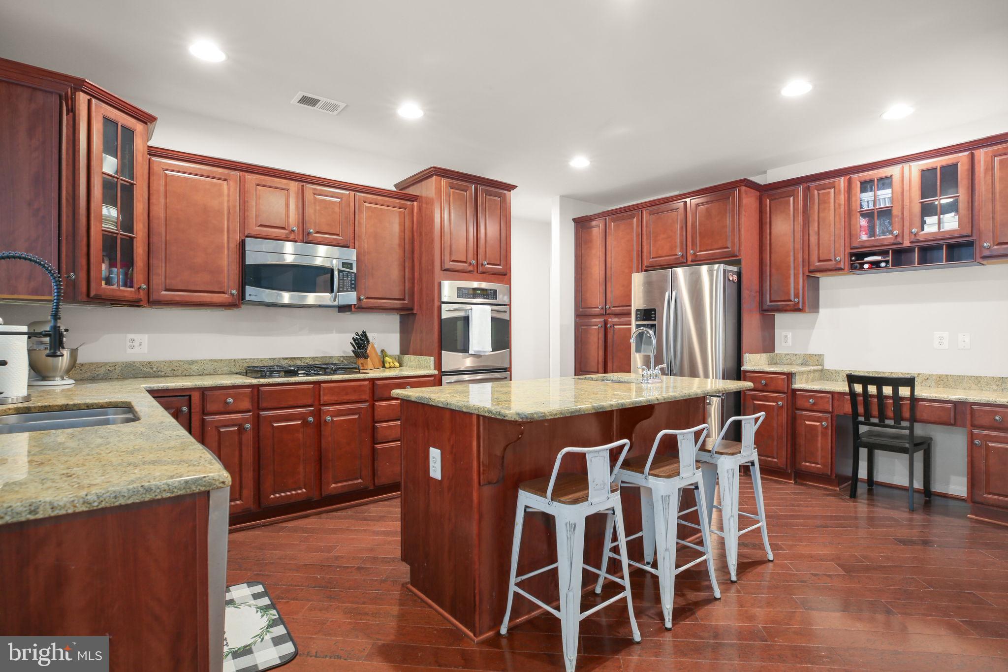 10108 Willow Ridge Lane Spotsylvania, VA 22553 - Photo 18 of 61 a kitchen with stainless steel appliances granite countertop table chairs sink and cabinets