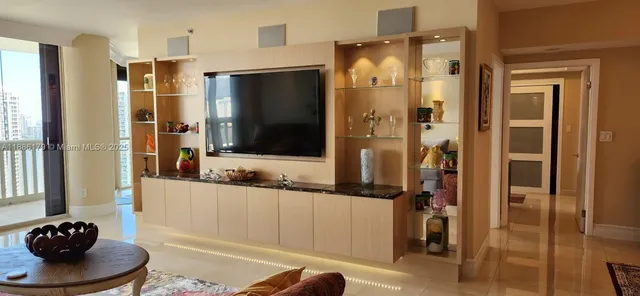 a living room with a flat screen tv and a large mirror