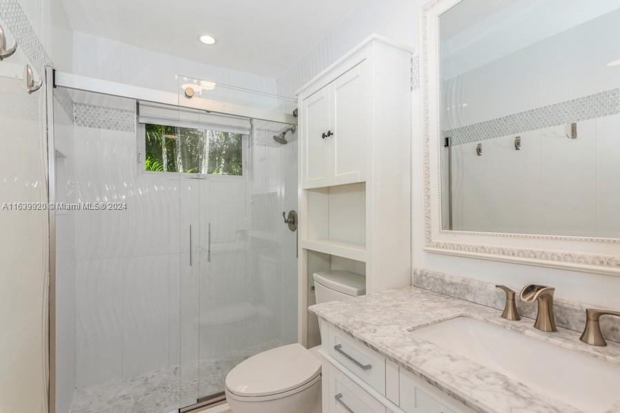 7772 Southwest 106th Terrace Pinecrest, FL 33156 - Photo 11 of 24 a bathroom with a granite countertop sink a toilet and shower