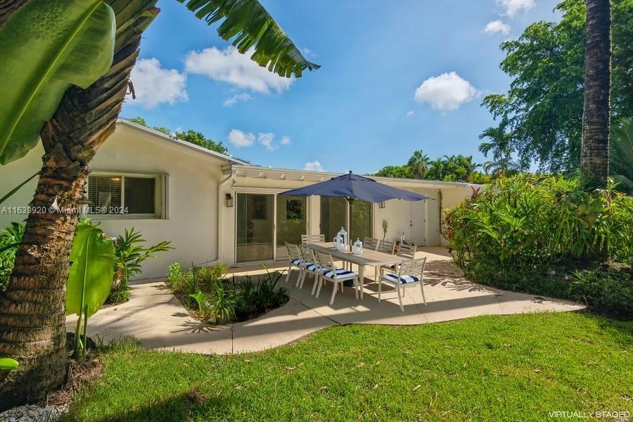 7772 Southwest 106th Terrace Pinecrest, FL 33156 - Photo 14 of 24 a front view of a house with a garden and patio