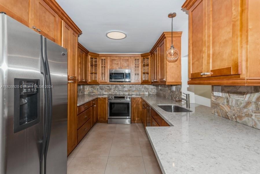 7772 Southwest 106th Terrace Pinecrest, FL 33156 - Photo 4 of 24 a kitchen with stainless steel appliances granite countertop a stove a sink and a refrigerator