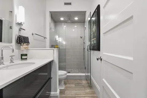 a bathroom with a sink a toilet and shower