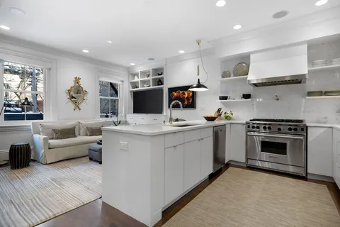 a kitchen with white cabinets and appliances