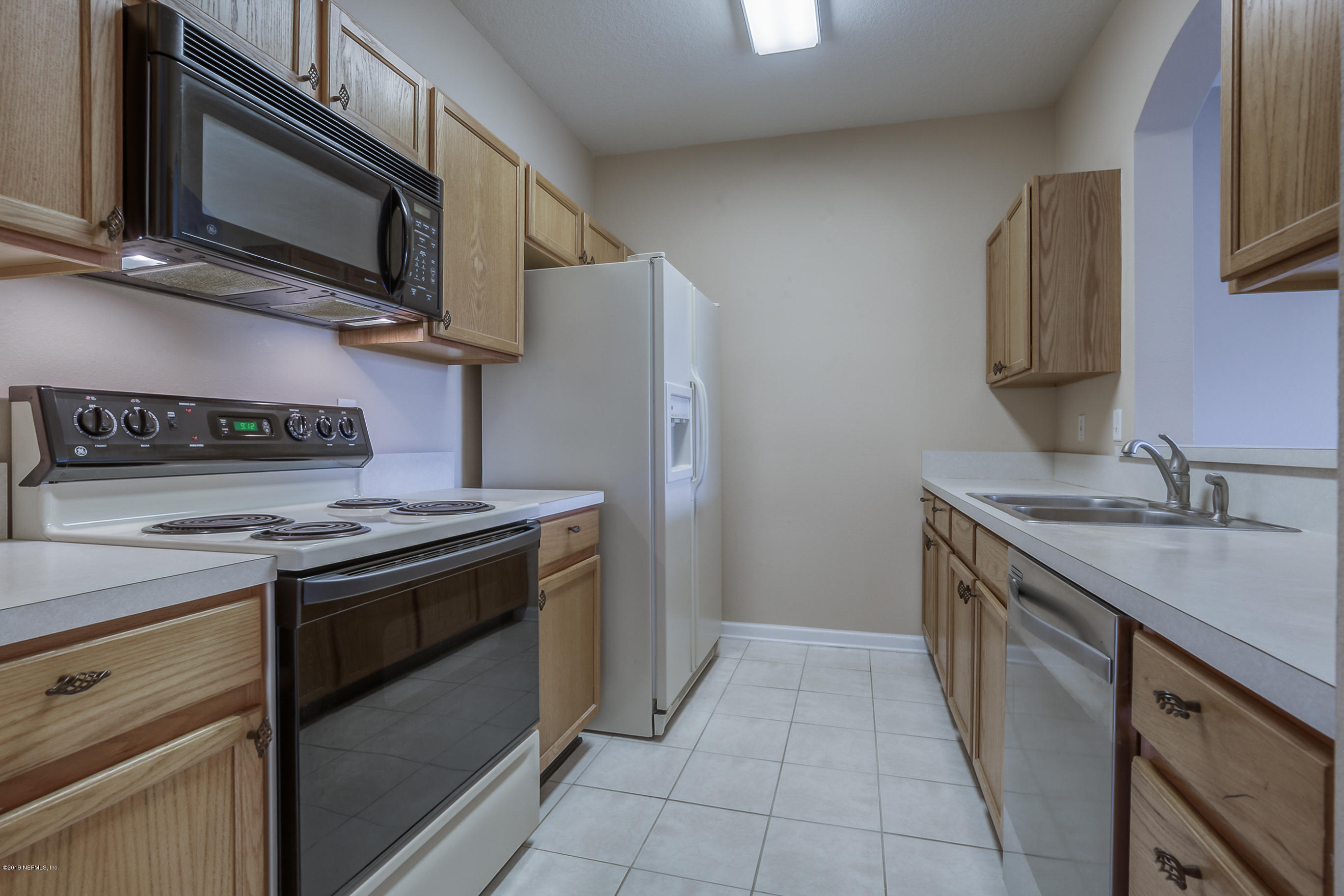 10550 Baymeadows Road, Unit 1023 Jacksonville, FL 32256 - Photo 7 of 42 a kitchen with stainless steel appliances granite countertop a stove microwave and sink
