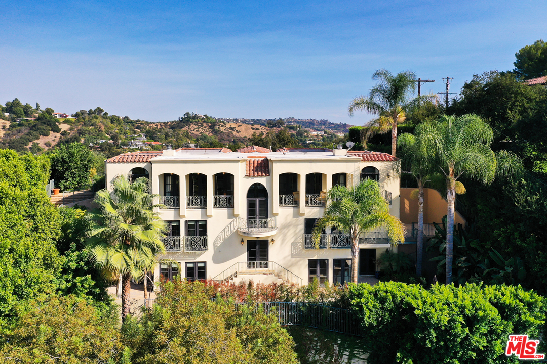 3110 Benedict Canyon Drive Beverly Hills, CA 90210 - Photo 2 of 45 a view of a large building with a lot of plants and trees around