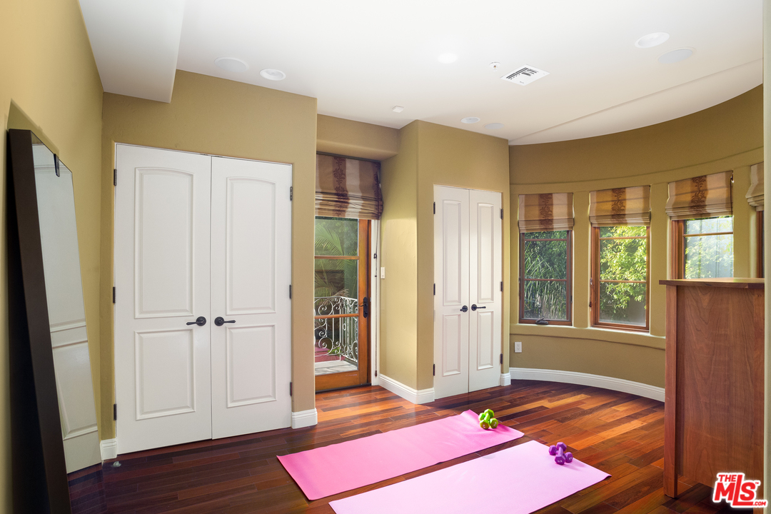 3110 Benedict Canyon Drive Beverly Hills, CA 90210 - Photo 28 of 45 a bedroom with a bed and wooden floor