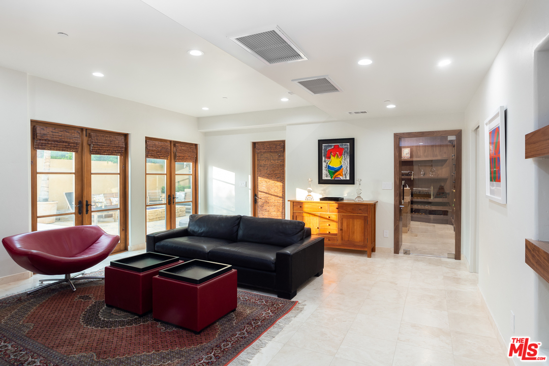 3110 Benedict Canyon Drive Beverly Hills, CA 90210 - Photo 29 of 45 a living room with furniture a large window and a flat screen tv