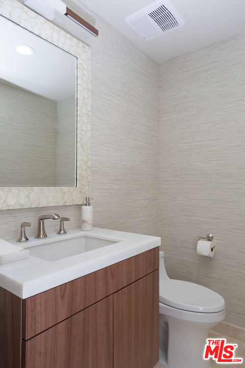 3110 Benedict Canyon Drive Beverly Hills, CA 90210 - Photo 32 of 45 a bathroom with a sink a toilet and a mirror