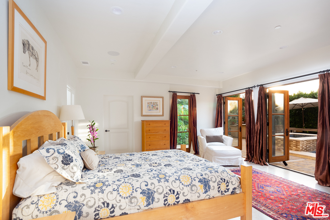 3110 Benedict Canyon Drive Beverly Hills, CA 90210 - Photo 33 of 45 a bedroom with a large bed and wooden floor