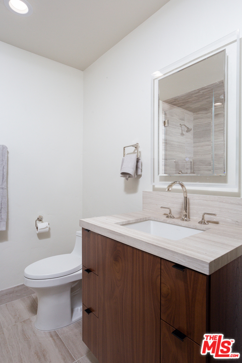 3110 Benedict Canyon Drive Beverly Hills, CA 90210 - Photo 34 of 45 a bathroom with a granite countertop sink a toilet and a mirror