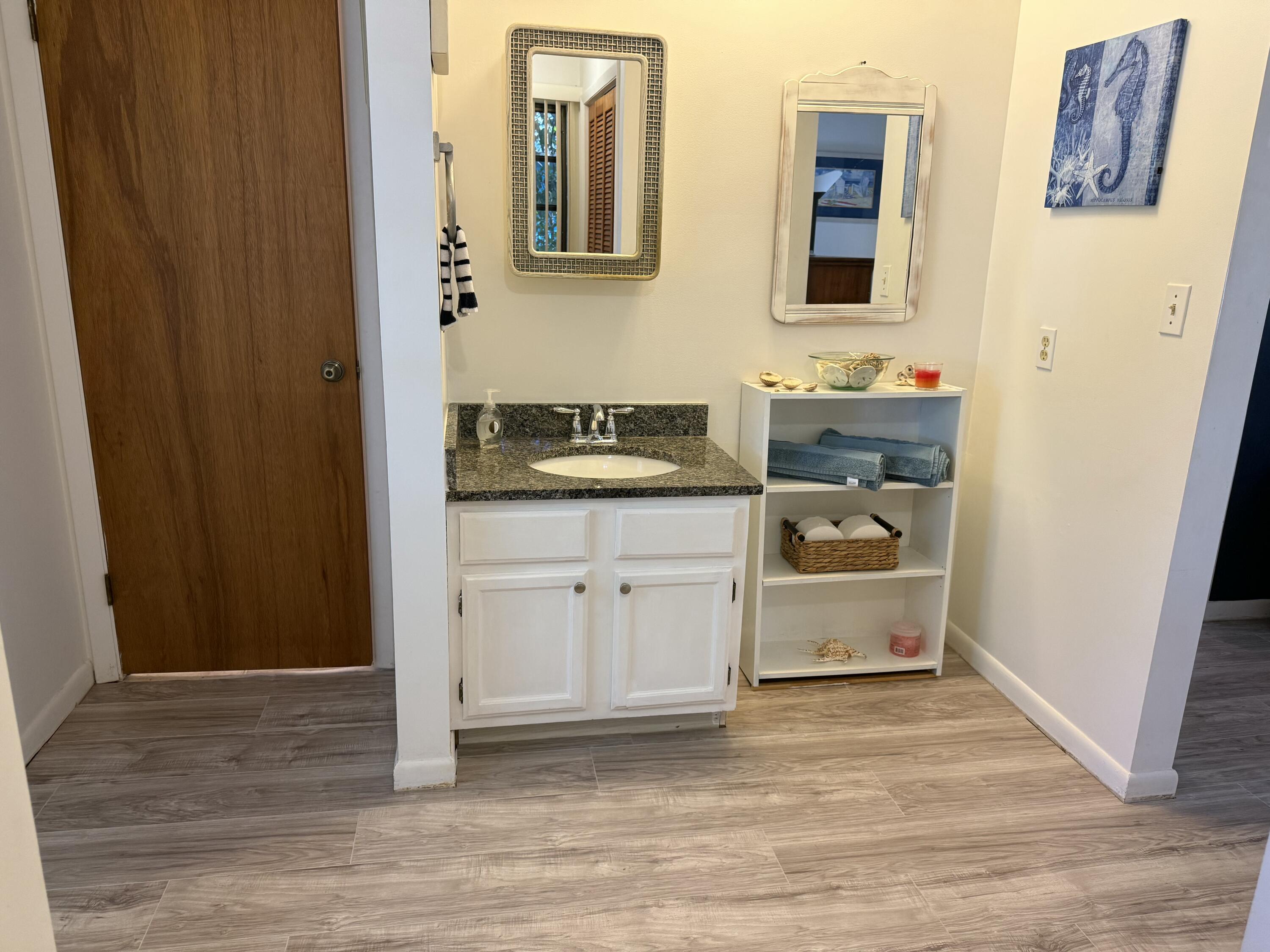 760 Musa Drive Key Largo, FL 33037 - Photo 11 of 20 a spacious bathroom with a granite countertop sink and a mirror