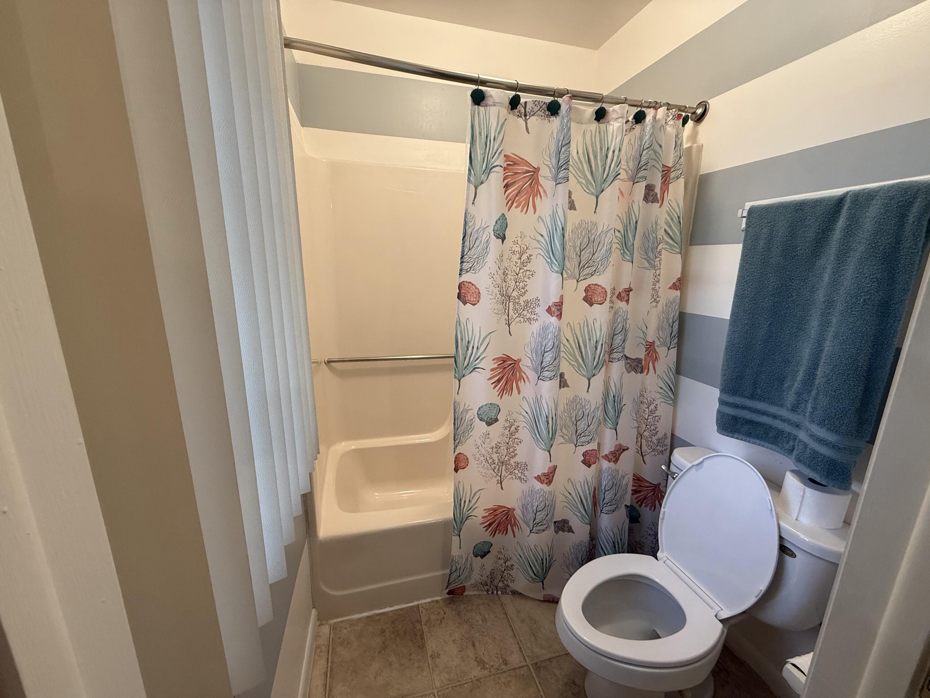 760 Musa Drive Key Largo, FL 33037 - Photo 13 of 20 a white toilet sitting next to a shower curtain