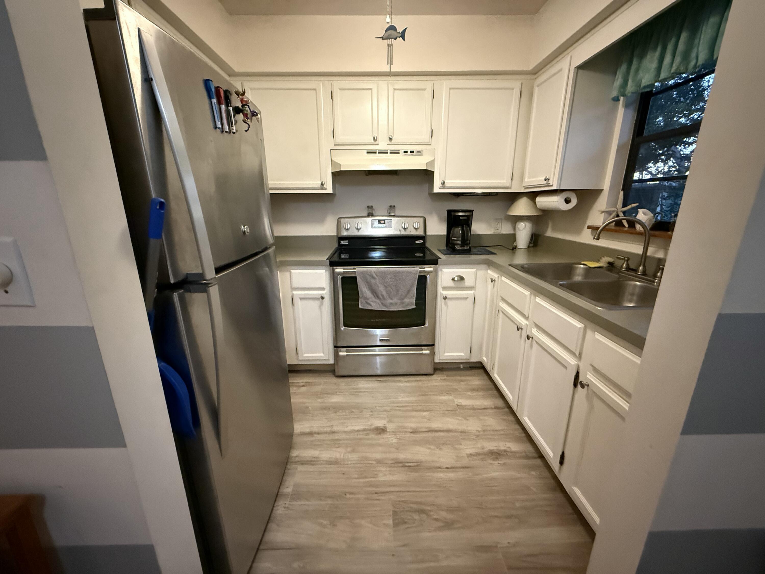 760 Musa Drive Key Largo, FL 33037 - Photo 20 of 20 a kitchen with white cabinets sink and a refrigerator
