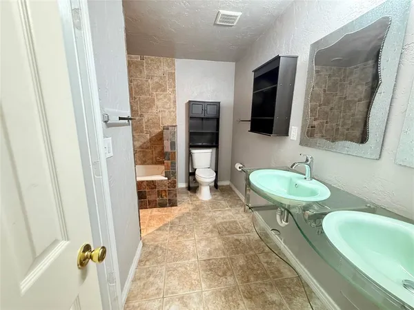 a bathroom with a sink a toilet and a mirror