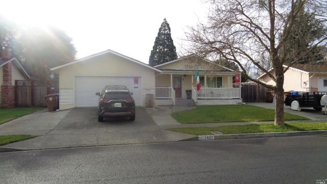 a car parked in front of a white house