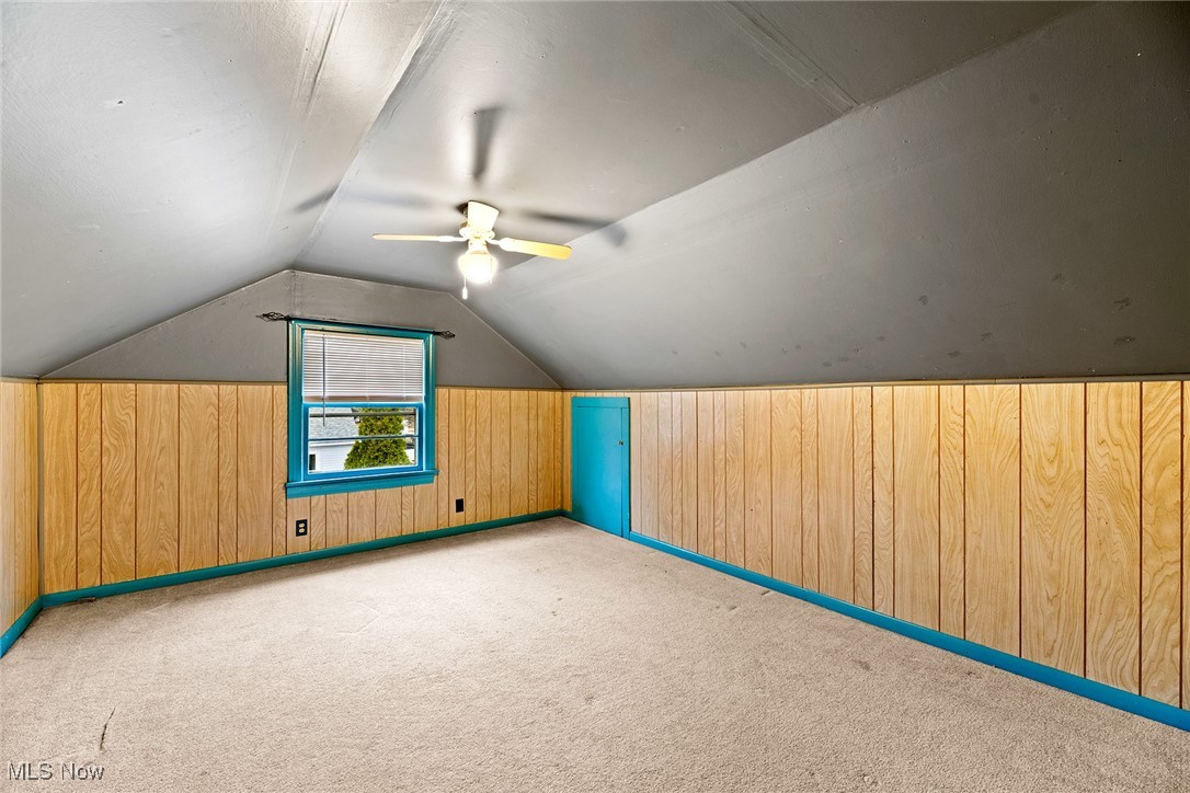 4556 Fishcreek Road Stow, OH 44224 - Photo 19 of 41 Bonus room featuring carpet floors, lofted ceiling, wooden walls, and a ceiling fan