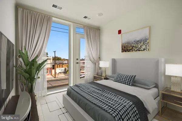 a bedroom with a large bed and a potted plant
