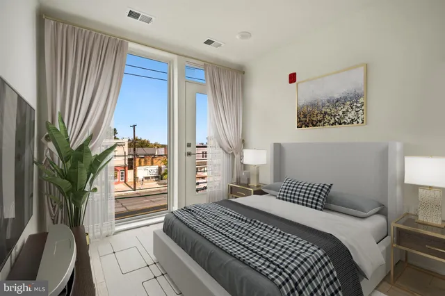 a bedroom with a large bed and a potted plant