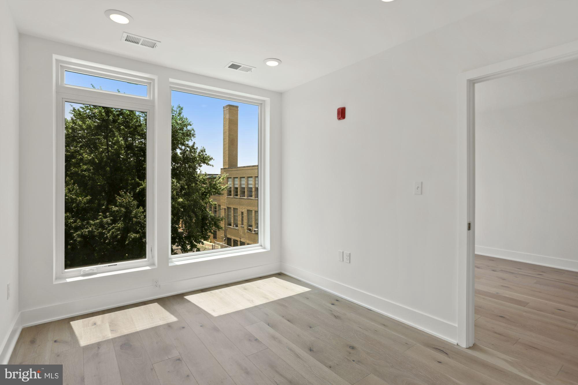 2027 Rhode Island Avenue Northeast, Unit 401 Washington, DC 20018 - Photo 19 of 29 an empty room with wooden floor and windows