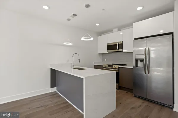 a kitchen with stainless steel appliances a refrigerator sink and microwave