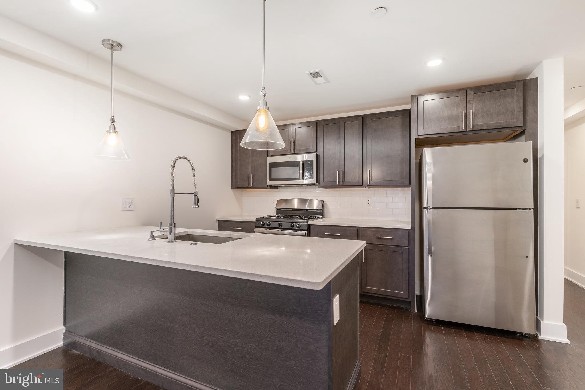 2612 Braddock Street, Unit 1 Philadelphia, PA 19125 - Photo 4 of 17 a kitchen with refrigerator a sink and cabinets