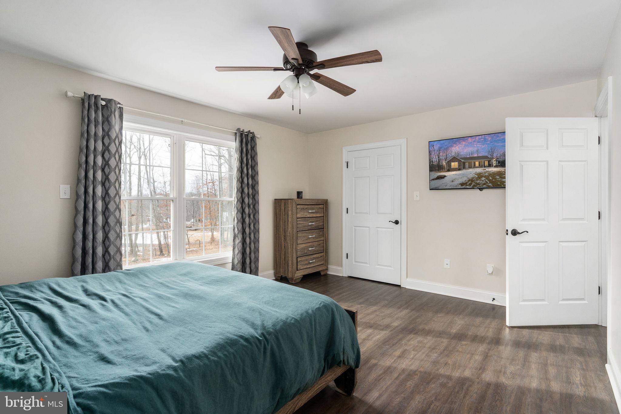 10514 Hart Court Culpeper, VA 22701 - Photo 14 of 34 a bedroom with a large bed and a ceiling fan