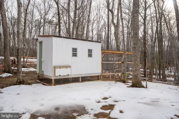 a backyard of a house with wooden fence and large trees
