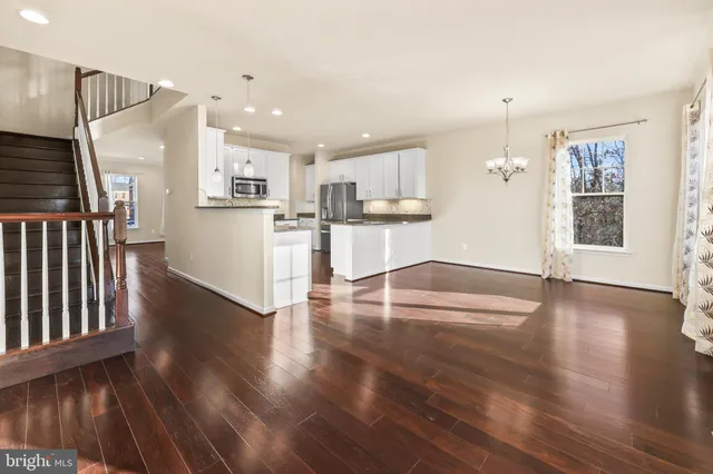 a view of a kitchen with wooden floor and electronic appliances