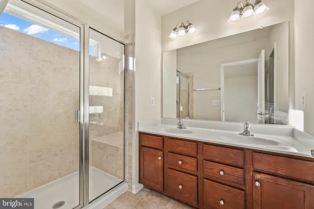 a bathroom with a granite countertop sink mirror and shower