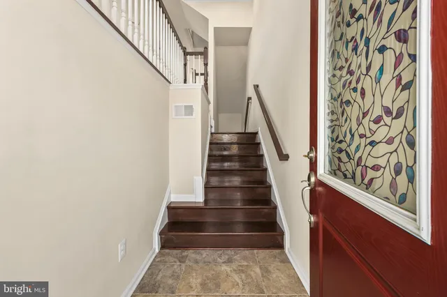a view of staircase with wooden floor and white walls