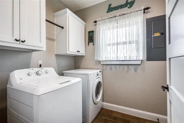 a kitchen with stainless steel appliances kitchen island granite countertop a refrigerator a sink a stove and white cabinets with wooden floor