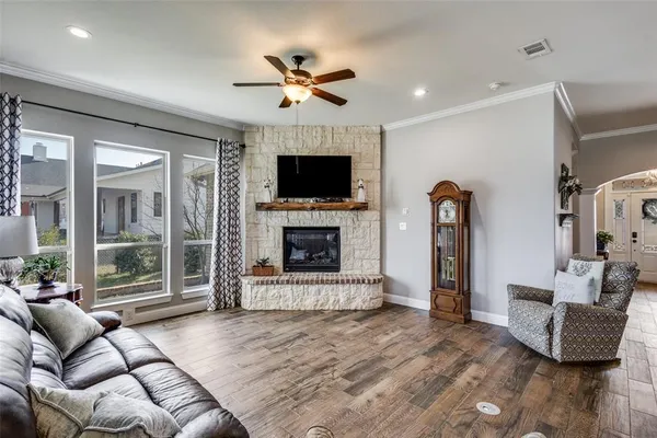 a living room with furniture a flat screen tv and a fireplace