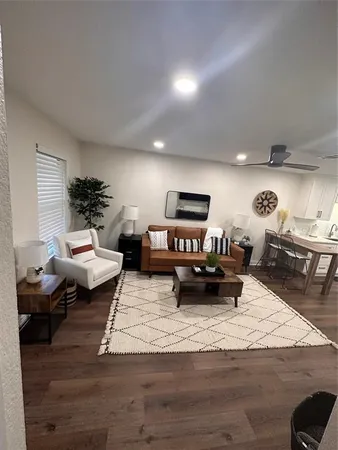 a living room with furniture and a wooden floor