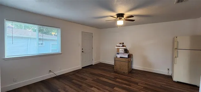 a view of a livingroom with wooden floor and a ceiling fan