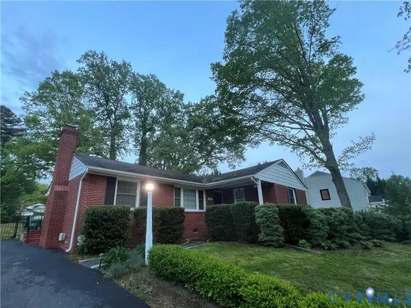 a front view of a house with a yard and green space