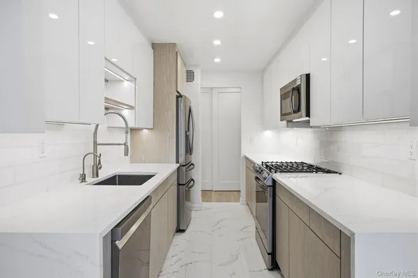 a kitchen that has a sink a stove and a refrigerator