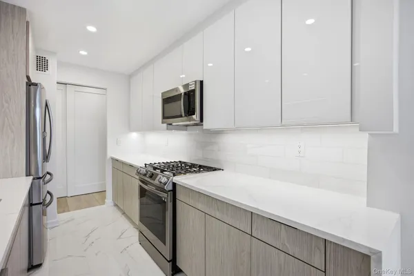 a kitchen with stainless steel appliances granite countertop a sink stove and refrigerator