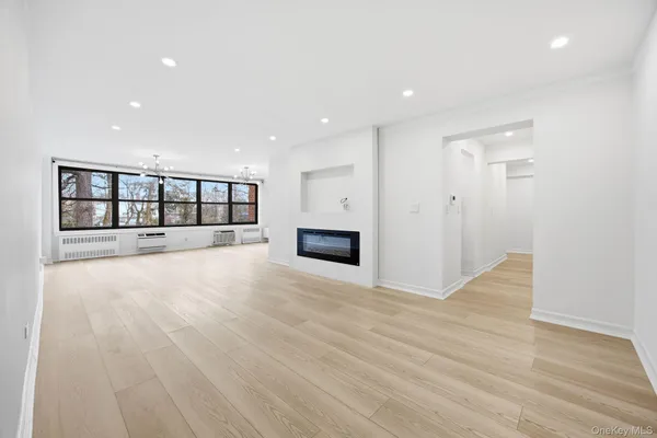 a view of an empty room with a fireplace and wooden floor