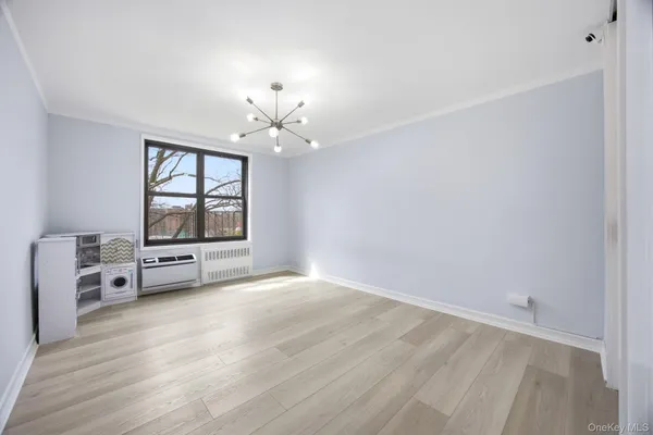 an empty room with windows and chandelier