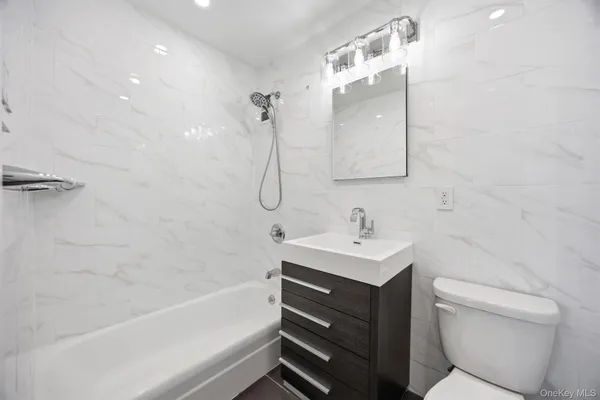 a bathroom with a sink toilet vanity and shower