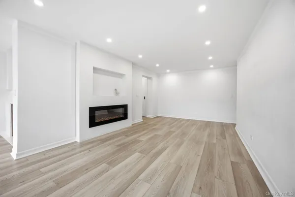 a view of a room with an empty space and a fireplace