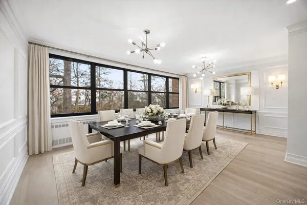 a dining room with furniture a rug and a chandelier