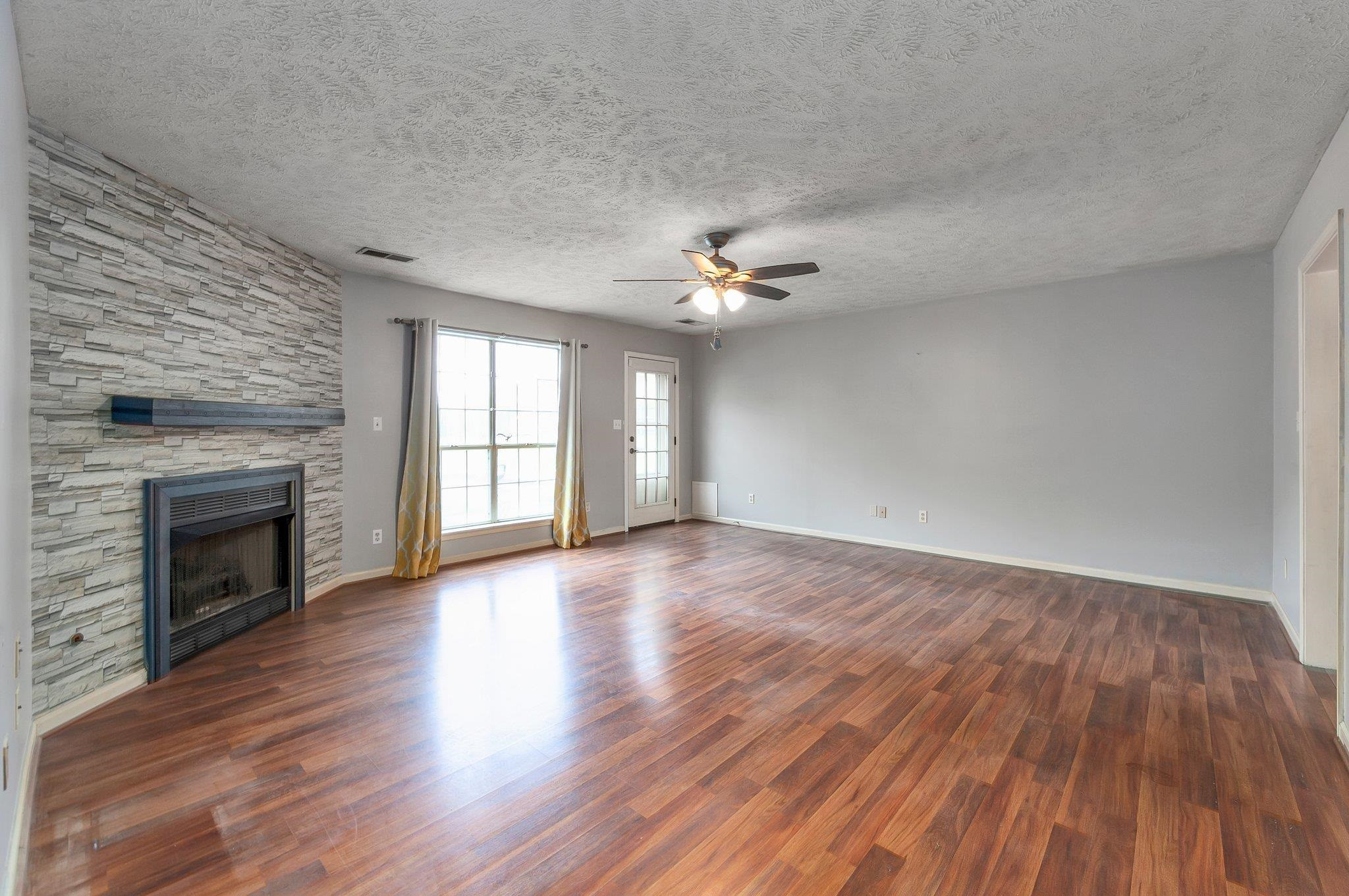 112 Penny Lane Jackson, TN 38301 - Photo 9 of 16 a view of an empty room with wooden floor fireplace and a window