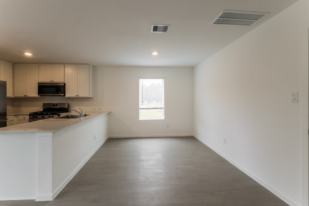 2084 Cedar Way Drive Conroe, TX 77301 - Photo 7 of 17 a kitchen with stainless steel appliances a sink a stove a microwave a refrigerator a window