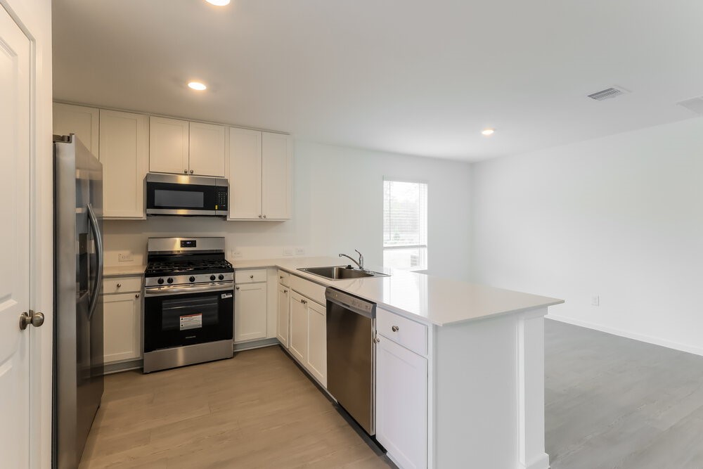 2084 Cedar Way Drive Conroe, TX 77301 - Photo 8 of 17 a kitchen with stainless steel appliances granite countertop a stove a refrigerator and a microwave